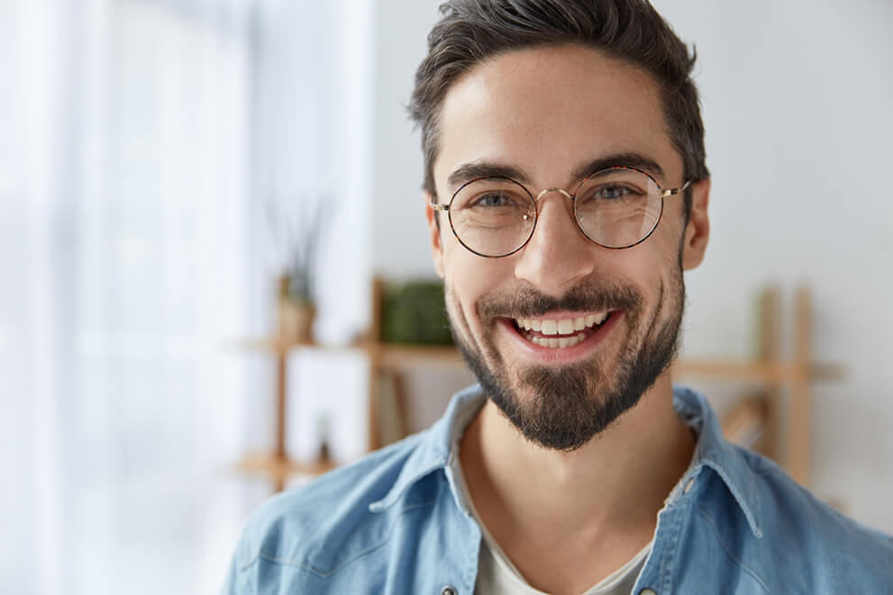 Young man with beard and round glasses