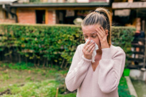 woman with allergies using tissue